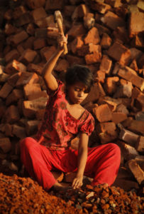 Child working in a brick crushing factory in Bangladesh